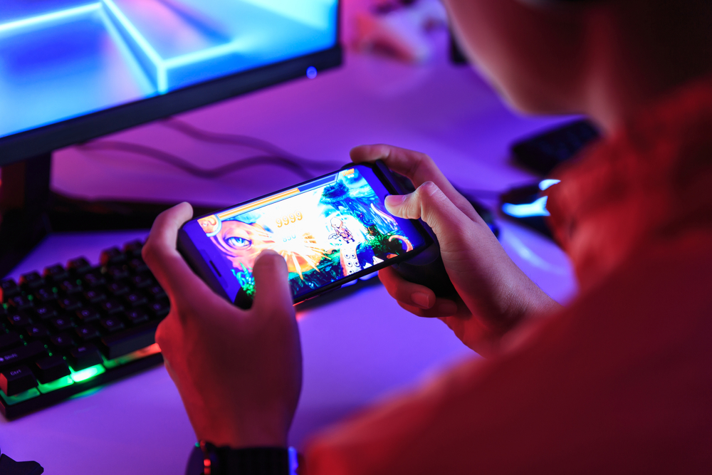 gamer,playing,online,game,on,smart,phone,in,dark,room.